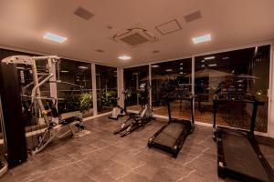 a gym with several treadmills and elliptical machines at Gaben Hotel in Jaú
