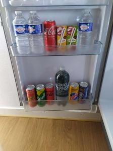 a refrigerator filled with drinks and cans of soda at Appartement T2- Le bon accueil / WIFI / PARKING in Angoulême