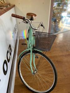 a green bike with a basket parked in a store at Hotel e pousada oca in Holambra