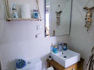 a bathroom with a sink and a toilet and a mirror at Casa Mar do Triângulo in Horta