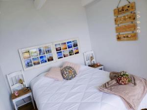 a bedroom with a white bed with two pillows on it at Casa Mar do Triângulo in Horta