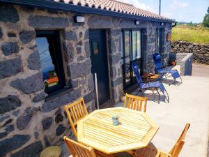 a wooden table and chairs on a patio at Casa Mar do Triângulo in Horta