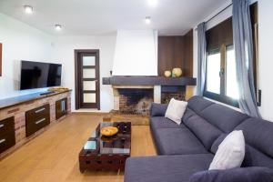 sala de estar con sofá y chimenea en Villa Del Sol, en Santa Cristina d'Aro