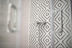 a shower in a bathroom with a white tile wall at Lizmary's Wonderland in Budapest +36 photos