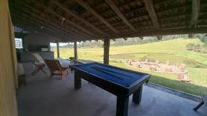 a pool table in a room with a view of a field at Hostel e Camping Vale Mirante da Rocha in Timbe do Sul