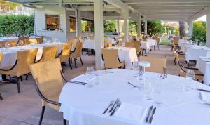 un restaurante con mesas y sillas con manteles blancos en Hotel Villa Elsa, en Marina di Massa