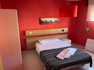 czerwona sypialnia z łóżkiem i czerwoną ścianą w obiekcie Residencia Vista Alegre w Santiago de Compostela