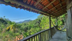 a balcony of a house with a view of the mountains at Sítio Cumuru in Paraty