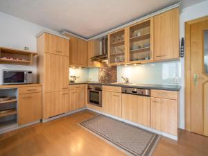 a kitchen with wooden cabinets and a rug on the floor at Seeberger II in Strengen