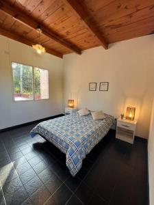 1 dormitorio con 1 cama, 2 mesas y una ventana en Casa Frente Parque Guillermina en San Miguel de Tucumán
