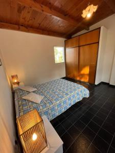 1 dormitorio con 2 camas y pared de madera en Casa Frente Parque Guillermina en San Miguel de Tucumán