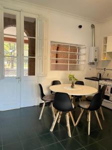 Casa Frente Parque Guillermina في سان ميغيل دي توكومان: مطبخ مع طاولة وكراسي في غرفة