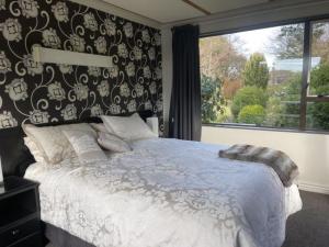 Un dormitorio con una cama grande y una ventana en Down South Cottage, en Invercargill
