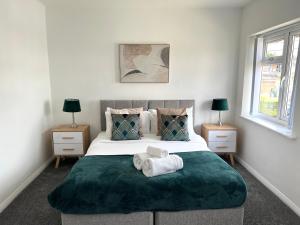 a bedroom with a large bed with towels on it at The Lambourne in Birstall