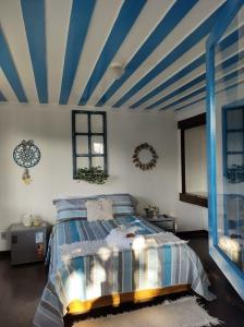 a bedroom with a blue and white striped ceiling at Mar de Maria Pousada in Búzios