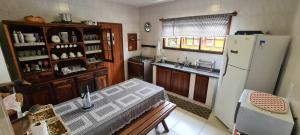 a kitchen with a refrigerator and a table in it at Casa de Temporada in Juquei