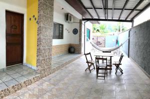 a patio with a table and chairs in a house at Chalés Alencar in Caraguatatuba