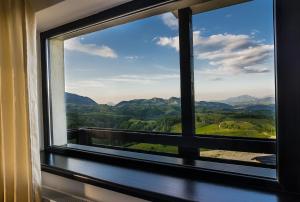 a window with a view of the mountains at Pensiunea Soarelui in Fundata