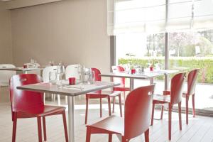 une salle à manger avec des tables et des chaises rouges dans l'établissement Campanile Mulhouse - Morschwiller, à Morschwiller-le-Bas