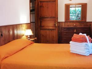 een slaapkamer met een bed met oranje lakens en een raam bij Villaggio Barilari in Minucciano
