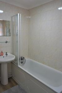 a bathroom with a white tub and a sink at Devonshire house-3.3ml from Wimbledon centre court in London