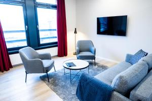 uma sala de estar com um sofá e duas cadeiras e uma mesa em Hotel Sønderborg Kaserne em Sonderborg