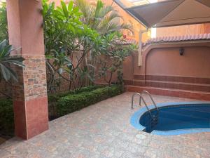 a swimming pool in a courtyard with a building at Magic Studio Pool View, New Cairo in Cairo
