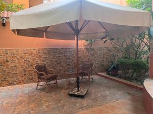 a table and chairs under an umbrella on a patio at Magic Studio Pool View, New Cairo in Cairo