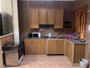 a kitchen with wooden cabinets and a microwave at Magic Studio Pool View, New Cairo in Cairo
