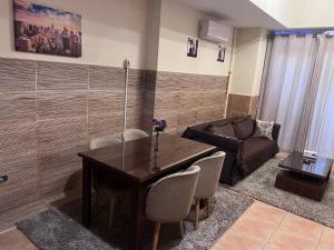 a dining room with a table and chairs and a couch at Magic Studio Pool View, New Cairo in Cairo