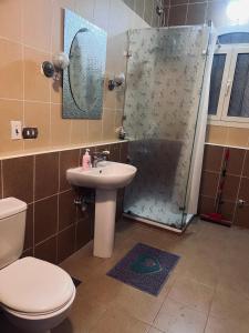 a bathroom with a toilet and a sink and a shower at Magic Studio Pool View, New Cairo in Cairo