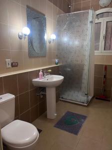 a bathroom with a toilet and a sink and a shower at Magic Studio Pool View, New Cairo in Cairo