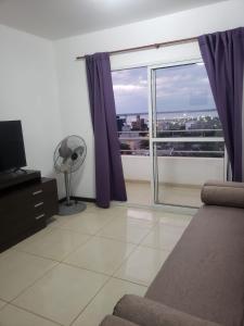 a living room with a large window with purple curtains at Departamento Augusta in Posadas