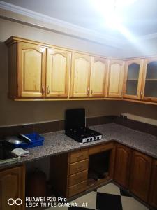 a kitchen with wooden cabinets and a laptop on a counter at Daya Rentals in Asilah