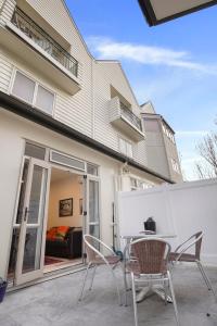 a patio with a table and chairs in front of a house at CBD Spacious 3 Storey Terrace House with Courtyard in Auckland