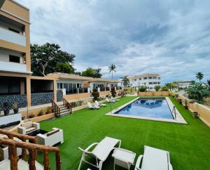 una imagen de un patio trasero con piscina y césped en Verde View Villas en Puerto Galera