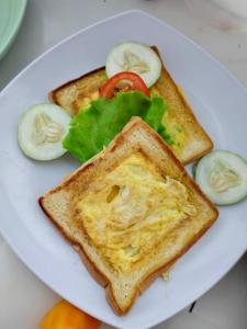 a white plate with two pieces of toast and vegetables at Casa di Stella in Ngurblut +6 photos