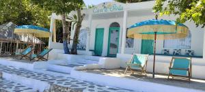 un groupe de chaises et de parasols devant un bâtiment dans l'établissement Casa di Stella, à Ngurblut