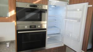 an empty refrigerator with its door open with its door open at AL CASA DE SÃO ROQUE in Caminha