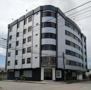 弗朗西斯科德奥雷利亚纳港Hotel Torre Orquídea的街角的一栋白色大楼