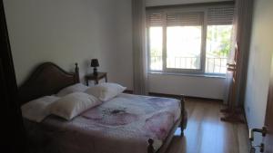 a bedroom with a bed and a window at AL CASA DE SÃO ROQUE in Caminha