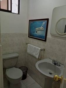 y baño con aseo y lavamanos. en Hermoso Apartamento al Norte cerca de la Embajada Americana, en Quito