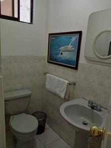 a bathroom with a toilet and a sink at Hermoso Apartamento al Norte cerca de la Embajada Americana in Quito +3 photos