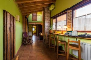 Hotel Rural Piedra Abierta في San Martín de Perapertú: مطبخ بجدران خضراء وكاونتر مع كراسي