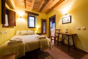 a bedroom with a bed and a table in it at Hotel Rural Piedra Abierta in San Martín de Perapertú