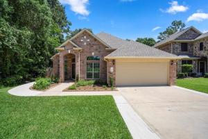 a house with a garage in a yard at Spacious Conroe Home around 4 miles to the Lake in Montgomery
