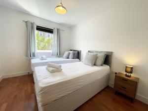 1 dormitorio con 2 camas y ventana en 17 Ocean one, en Newquay