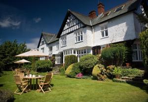 ein Haus mit einem Tisch und Stühlen im Hof in der Unterkunft Lindeth Howe in Bowness-on-Windermere