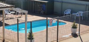 een hek rond een zwembad in een tuin bij Centrepoint Motel Deniliquin in Deniliquin