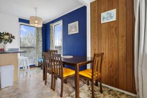 a dining room with a wooden table and chairs at Family 3BR Home with Netflix and Fully Fenced Yard in Auckland